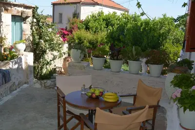 a table and chairs with a bowl of fruit on it at Sergios Village House in Chania Town