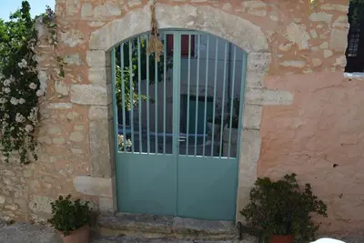 a blue door with a metal gate in a brick building at Sergios Village House in Chania Town