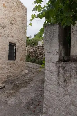 an old stone building with a window on the side at Sergios Village House in Chania Town