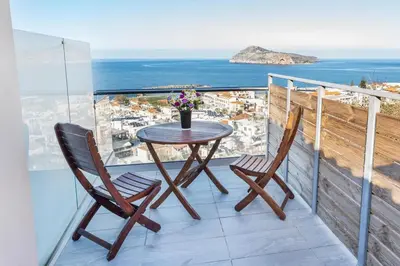 a table and two chairs on a balcony with the ocean at Platania's Paradise in Chania Town