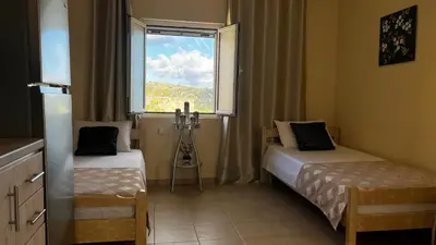 a small room with two beds and a window at Chrispa's House in Chania Town
