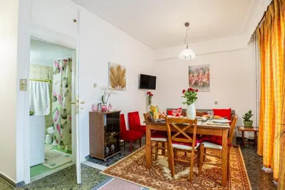 a dining room with a table and red chairs at Katerina's Apartment in Chania Center in Chania Town