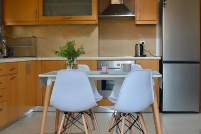 a kitchen with a table and three white chairs at Chania Sweet Apts in Chania Town