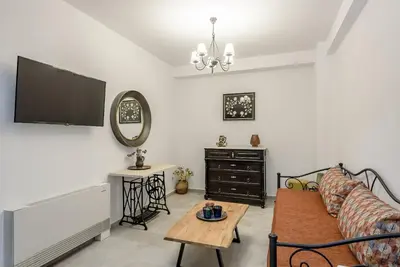a living room with a couch and a tv at Minos Country Living Apartments in Agrilés