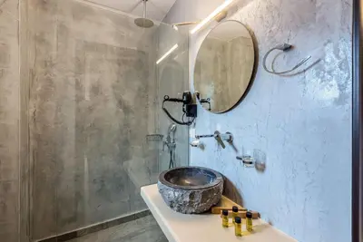 a bathroom with a sink with a mirror and a shower at Minos Country Living Apartments in Agrilés