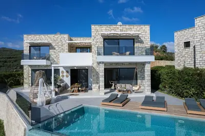 a house with a swimming pool in front of it at Argyrie Villas, luxury, amazing sea view, heated pool in Kalleryianá