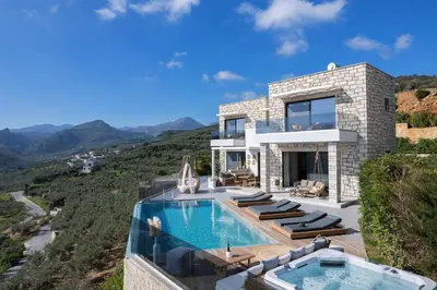 a villa with a swimming pool on a hill at Argyrie Villas, luxury, amazing sea view, heated pool in Kalleryianá