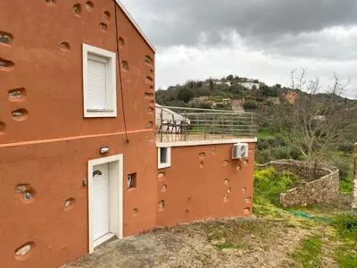 a brick building with a white door and a balcony at Pulchra Campis,Private Pool,Wifi,Parking in Nerokoúros
