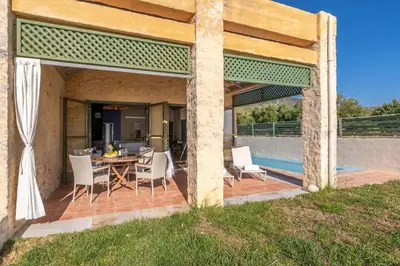 a patio with a table and chairs on a deck at Villa Mediterranea - Heated Pool optional in Livadia