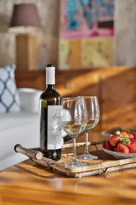 a bottle of wine and two wine glasses on a table at Villa Mediterranea - Heated Pool optional in Livadia