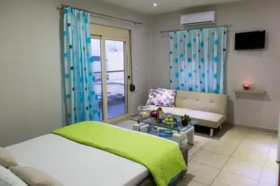 a bedroom with a bed and a couch and a table at Litinakis Studios Sea View & Litinakis Studios Garden View 700 meters away in Agia Marina Nea Kydonias