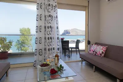 a living room with a couch and a large window at Litinakis Studios Sea View & Litinakis Studios Garden View 700 meters away in Agia Marina Nea Kydonias