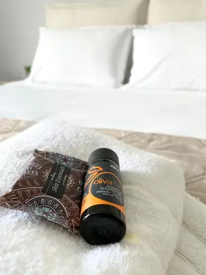 a bottle of alcohol sitting on top of a bed at Wave rooms in Maleme