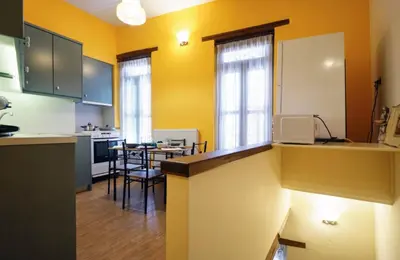 a kitchen with yellow walls and a table and chairs at Character House in the Heart of Chania Old town in Chania Town
