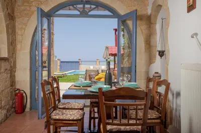 a dining room with a table and chairs and a window at Villa Anastasia Kalyves in Kalyves