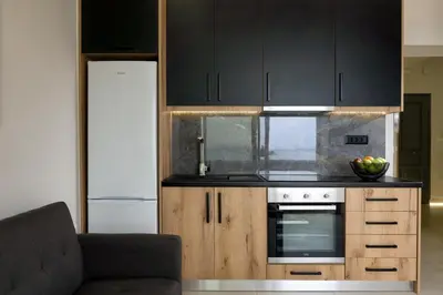 a kitchen with black cabinets and an oven at Just Creta Sea View apartment in Chania Town