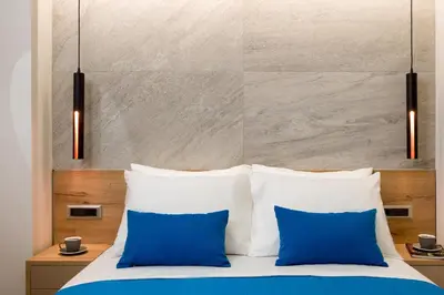 a bedroom with blue and white pillows on a bed at Just Creta Sea View apartment in Chania Town