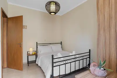 a bedroom with a bed with a black frame and a lamp at Amphitrite Beach House in Chania Town
