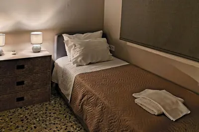 a small bedroom with a bed and a night stand at 4 Guests - Veneris Residence Apartment in Chania in Chania Town