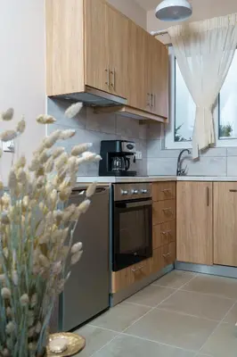 a kitchen with wooden cabinets and a stove top oven at RODOU Suites & Villas in Chania Town