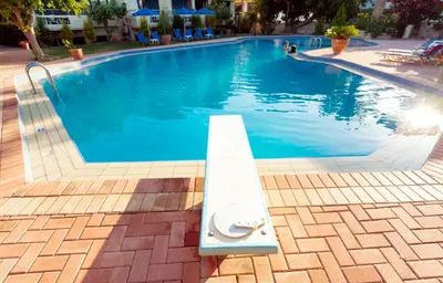 a swimming pool with a bench in the middle at Lili Apartments,oasis 2,5 km from Hania center in Parigoría