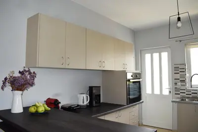 a kitchen with white cabinets and a black counter top at Elizabeth cozy home close to the beach in Chania Town