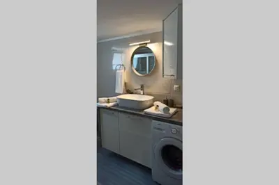 a bathroom with a sink and a washing machine at GS Lumen Apartment in Chania Town