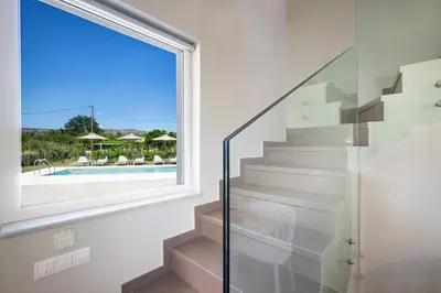 a glass staircase in a house with a window at MM Villa in Chania Town