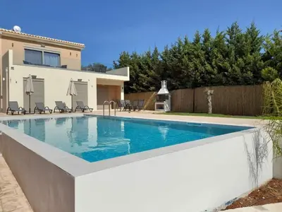 a swimming pool in front of a house at Villa Dedalos in Kalamitsi Amygdali