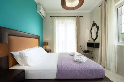 a bedroom with a bed with white sheets and a window at Casa Regno in Ayiá