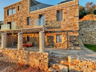 a stone house with a deck on a stone wall at INO III Domus SWIMSPA by Amigdalokefali Elafonissi in AmigdhalokeFálion