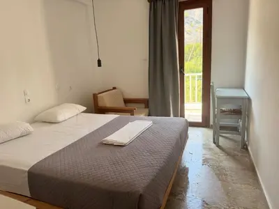a bedroom with a bed and a table and a window at Zorbas in Sougia