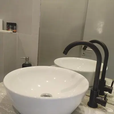 a bathroom with a white sink and a faucet at Zorbas in Sougia