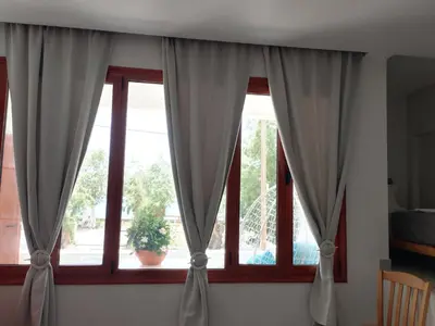 two windows with curtains in a room at Zorbas in Sougia