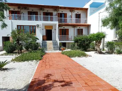 a white house with a red brick walkway at Zorbas in Sougia