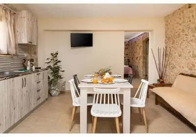 a kitchen and dining room with a table and chairs at Poseidon Apartments in Kissamos