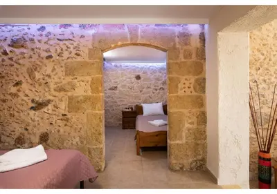 a room with a bed in a stone wall at Poseidon Apartments in Kissamos