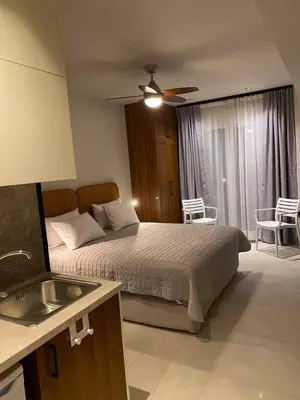 a bedroom with a bed with a ceiling fan and a sink at Houmas Apartments in Yialós