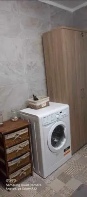 a washing machine sitting next to a wooden cabinet at Haroupia in Elafonisi