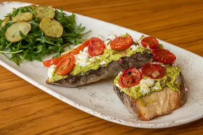 two slices of bread with tomatoes and a salad on a plate at Anassa Chania Boutique Hotel in Chania Town