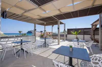 a patio with tables and chairs on a roof at xSuites - Adults Only Boutique Suites with Private Jacuzzi in Agia Marina Nea Kydonias