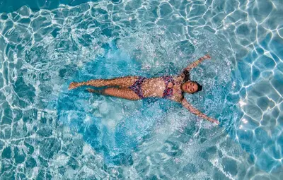 a woman laying in a pool of water at xSuites - Adults Only Boutique Suites with Private Jacuzzi in Agia Marina Nea Kydonias