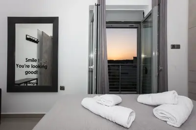 two towels on a bed in a room with a window at Villagio House in Falasarna