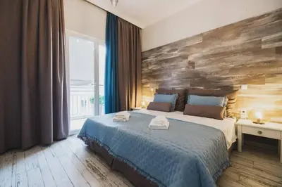 a bedroom with a large bed with a wooden wall at D&G Lux City Flat next to Old Town and Market in Chania Town