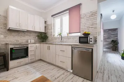 a kitchen with white cabinets and a sink and a microwave at D&G Lux City Flat next to Old Town and Market in Chania Town