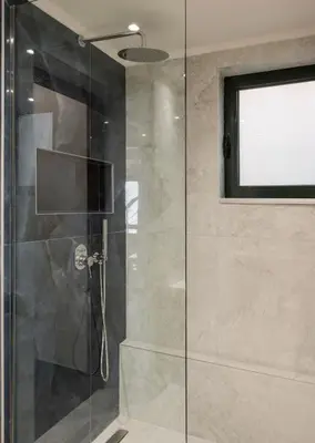 a shower with a glass door and a window at Villa City View - Heated Pool & Gym - Majestic views - 5 min drive from center in Chania Town