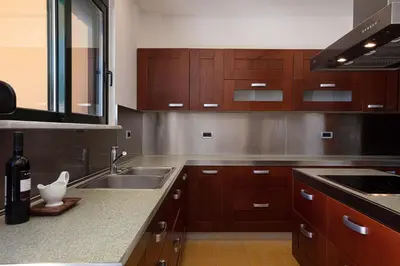 a kitchen with wooden cabinets and a sink at Villa City View - Heated Pool & Gym - Majestic views - 5 min drive from center in Chania Town