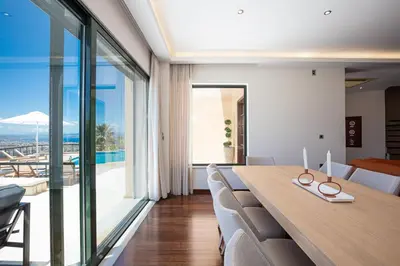 a dining room with a table and chairs and a large window at Villa City View - Heated Pool & Gym - Majestic views - 5 min drive from center in Chania Town
