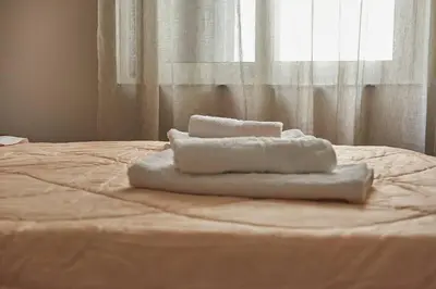 a pile of towels sitting on top of a bed at evgenia's city apartment in Chania Town
