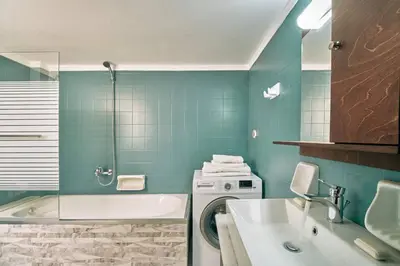 a bathroom with a sink and a washing machine at evgenia's city apartment in Chania Town
